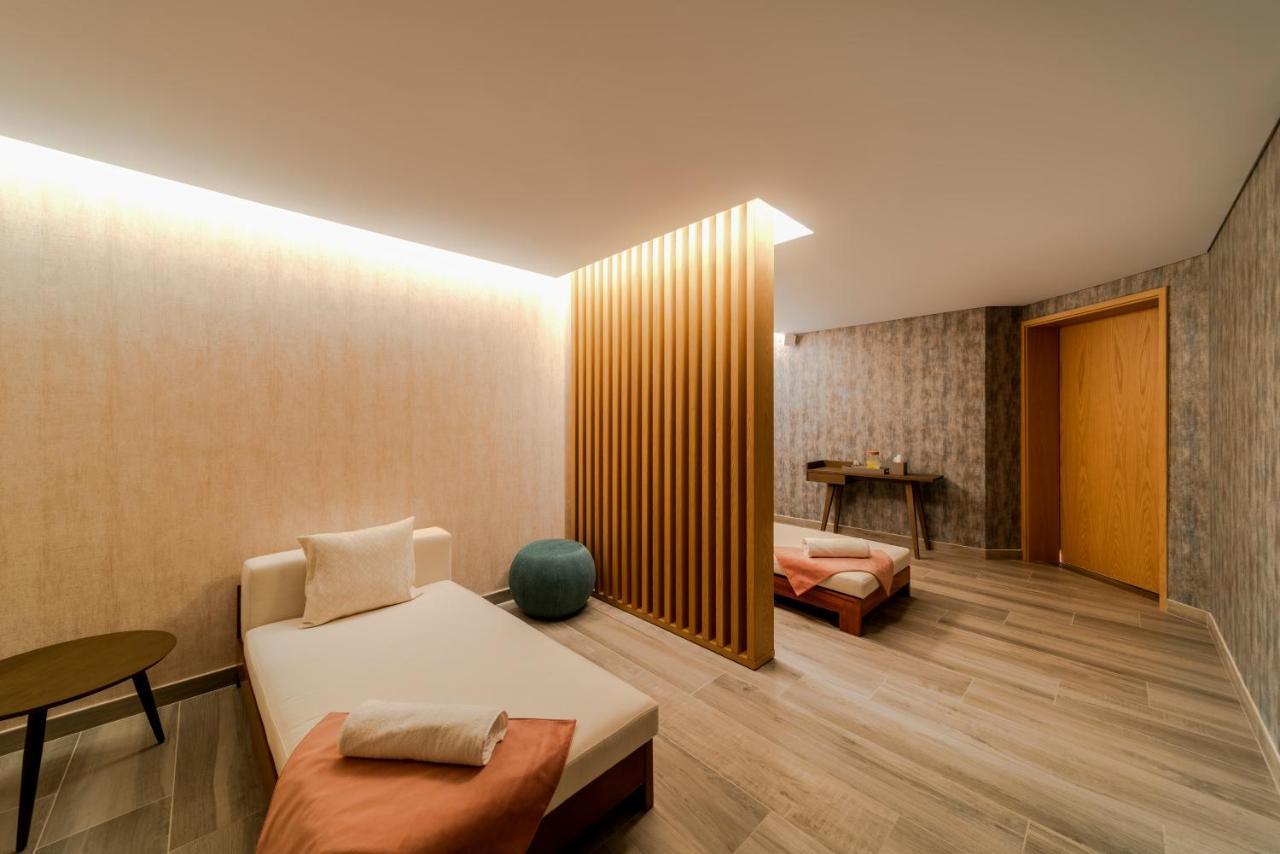 Five Jumeirah Village Dubai Buitenkant foto The photo depicts a calm and modern interior space, likely a relaxation or wellness area. It features a light-colored wood floor and soothing wall textures. 

On one side, there’s a daybed with soft cushions, accompanied by a small round table. A blu