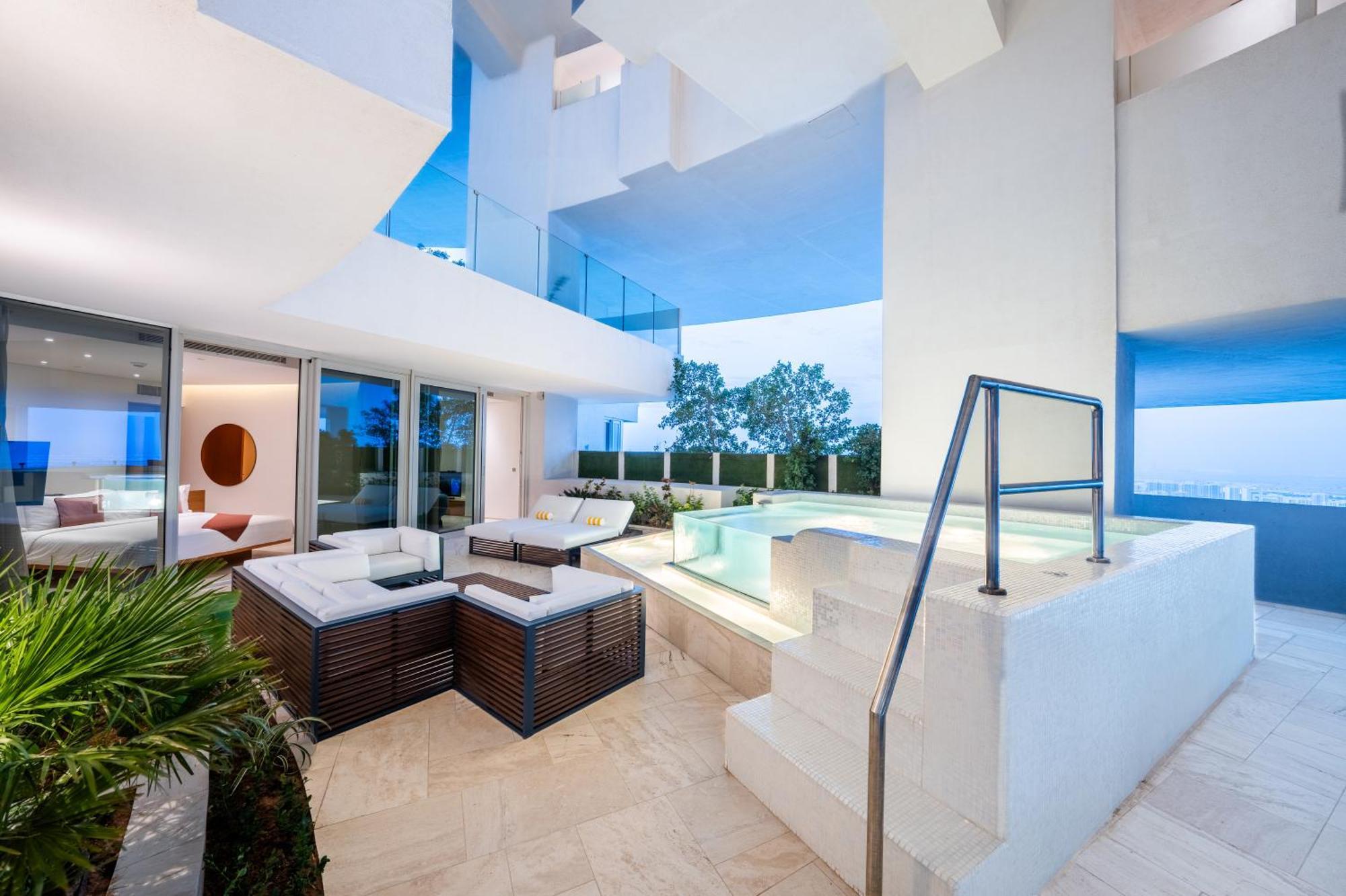 Five Jumeirah Village Dubai Buitenkant foto The photo shows a modern and stylish outdoor area that appears to be part of a contemporary residence. It features a seating arrangement with a lounge set made of dark wood and cushions, providing a comfortable space for relaxation. Nearby, there is 